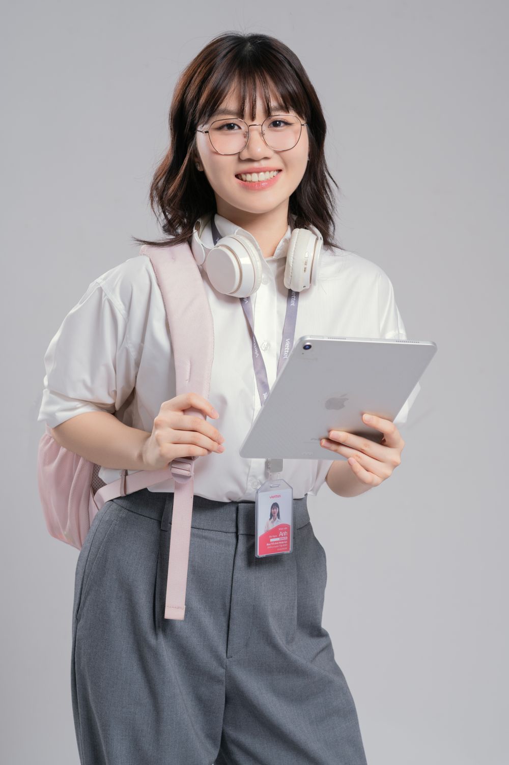 Estudante sorrindo com um tablet nas mãos
